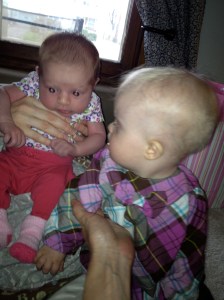 Lyra looking like a big girl next to her newborn buddy, Cora.