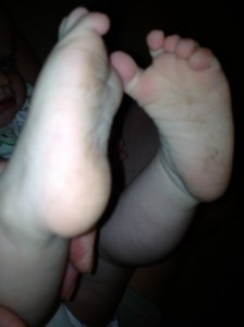 Lyra's feet, dirty from playing in the grass
